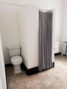 a bathroom with a toilet and a shower curtain at Charming 3BR Near Ponce Attractions in Ponce
