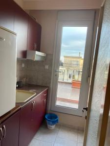 a kitchen with a sink and a door with a window at Serres central house in Serres