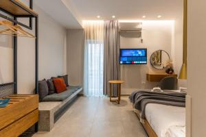 a bedroom with a bed and a couch and a tv at K35 Apartments in Preveza