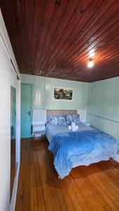 a large bed in a bedroom with a wooden ceiling at Casa Privativa no Centro de Urubici - Casa Doce Luar in Urubici