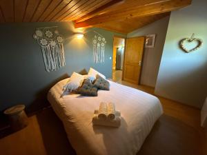 a bedroom with a bed with two towels on it at Gîte Le 1935 Évasion en Ardèche, au cœur de la campagne, idéal pour balades à vélo et moto in Saint-Sylvestre