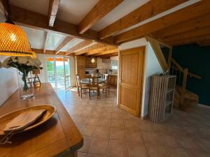 a kitchen and dining room with a table and chairs at Gîte Le 1935 Évasion en Ardèche, au cœur de la campagne, idéal pour balades à vélo et moto in Saint-Sylvestre
