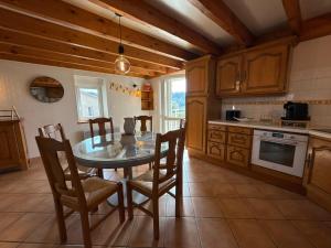 a kitchen with a table and chairs in a room at Gîte Le 1935 Évasion en Ardèche, au cœur de la campagne, idéal pour balades à vélo et moto in Saint-Sylvestre +10 photos