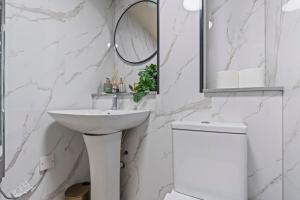 a white bathroom with a sink and a mirror at Urban Luxe Loft Hideaway in Central Station +17 photos