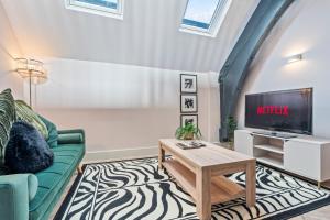 a living room with a couch and a tv at Urban Luxe Loft Hideaway in Central Station