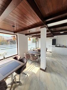 a dining room with tables and chairs and a large window at White Residence in Arad