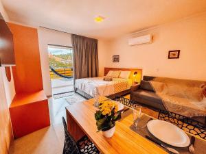 a hotel room with a bed and a living room at Centro | Studio Completo até 4 pessoas in Brusque