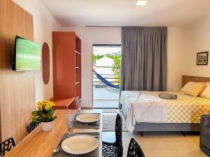 a room with a bed and a table with a dining room at Centro | Studio Completo até 4 pessoas in Brusque +17 photos