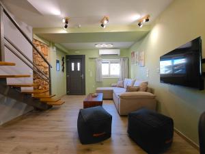 a living room with a couch and a tv at Aria home in Tsoukalades