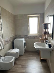 a bathroom with a toilet and a sink and a toilet istg at Apartment Le Forge in Policoro +7 photos