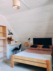 a bedroom with a bed with a wooden headboard at Domek Sielski Zakątek Pieniny in Szczawnica