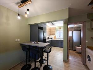 a kitchen and living room with a table and chairs at Aria home in Tsoukalades