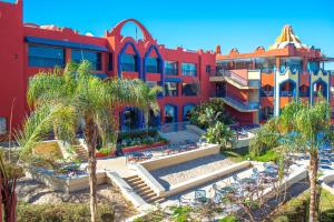 a hotel with palm trees in front of it at Cardina Resort in Marsa Alam City