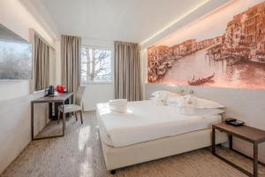 ein Hotelzimmer mit einem Bett und einem Gemälde an der Wand in der Unterkunft Antony Hotel - Venice Airport in Campalto