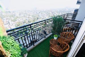 a balcony with chairs and a view of a city at Sunleaf Studio Pari Chawk Expo Mart in Greater Noida