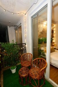 a balcony with two chairs and a bed in a room at Sunleaf Studio Pari Chawk Expo Mart in Greater Noida