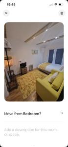 a bedroom with two beds and a green couch at Lovely garden cabin in Luton