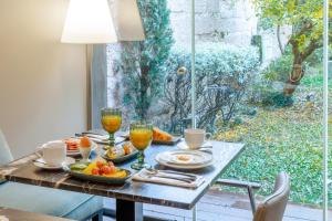 a table with food and drinks on it with a window at Casa do Juncal in Guimarães