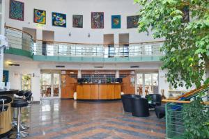 a large lobby with a bar in the center at Highway Hotel Dasing-Augsburg, ehemals Trip Inn Hotel Dasing in Dasing