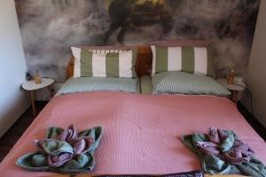 a bedroom with a pink bed with flowers on it at Appartement Erzgebirge in Schönheide