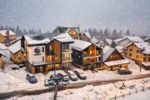 a snow covered town with buildings and cars parked at Celeste Villa Boutique in Ranca