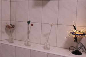 three vases with flowers in them on a shelf at Appartement Erzgebirge in Schönheide
