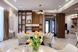 a dining room with white chairs and a table with flowers at Celeste Villa Boutique in Ranca