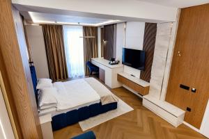 a hotel room with a bed and a television at Celeste Villa Boutique in Ranca