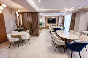 a dining room with tables and chairs and a television at Celeste Villa Boutique in Ranca