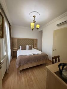 a bedroom with a bed and a chandelier at Hotel Varios in Batumi