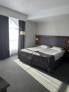 a bedroom with a large bed with a large window at Optima Collection Bergshloss Rivne in Rivne