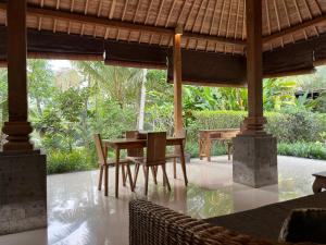 a dining room with a table and chairs at Thani Villa Ubud in Ubud