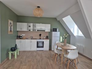 a kitchen with white cabinets and a table and chairs at le St fursy 31 in Péronne