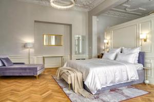 a bedroom with a large bed and a purple couch at Hotel Traugutta 12 in Łódź