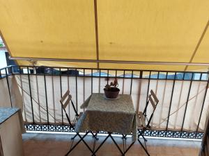 a table and chairs with a plant on a balcony at Heidi's home in Villabate