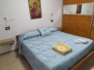 a bedroom with a bed with a blue comforter at Heidi's home in Villabate
