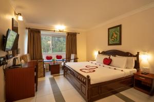a hotel room with a bed and a window at Las Palmas in Munnar +27 photos