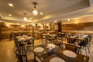 a restaurant with tables and chairs in a room at Las Palmas in Munnar