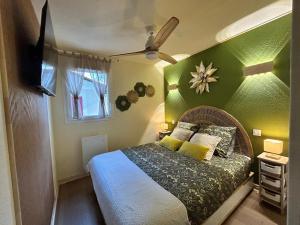 a bedroom with a bed with a green wall at Le Trésor du Lac - Casteljaloux - Lac de Clarens - Appartement - Piscine - Parking - WIFI - Accès privée Plage - Golf - Casino - Terra Aventura - So Vélo in Casteljaloux
