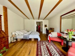 a living room with a bed and a red couch at Studio Auenland in Kottingbrunn