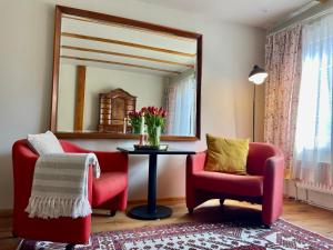 a living room with two chairs and a table and a mirror at Studio Auenland in Kottingbrunn