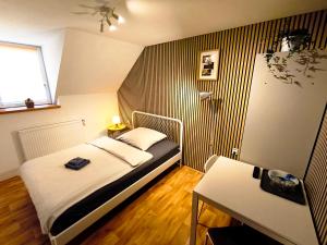 a small bedroom with a bed and a table at Ubytování U Tajčů in Dolní Beřkovice