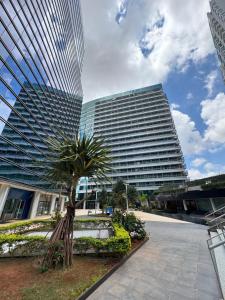 a large building with a palm tree in front of it at Fusion e Vision Flats in Brasília