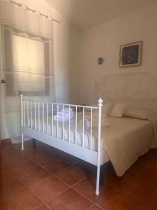 a white crib in a bedroom with a window at Casa Malò 2 in Ovile la Marinella