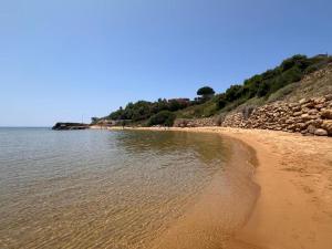 a sandy beach with rocks and the water at Casa Malò 2 in Ovile la Marinella +18 photos