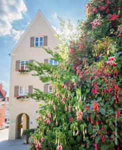 a house with pink flowers in front of it at Schieners Hotel & Apfelhof Apartments in Wemding