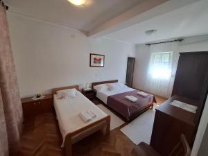 a room with two beds and a table in it at Marija šimičić in Rab