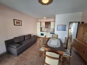 a living room with a couch and a dining room table at Marija šimičić in Rab