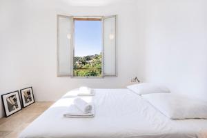 a white bedroom with a large bed with a window at House on the Hill in Nice +24 photos