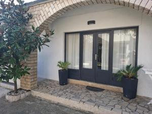 a black door on a house with two potted plants at Marija šimičić in Rab